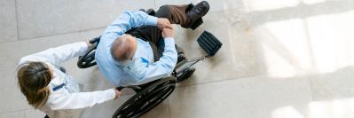 nurse pushing patient in wheelchair